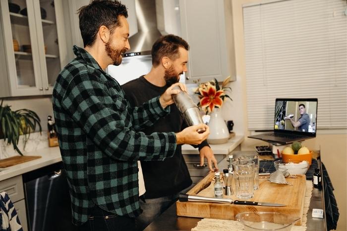 couple shaking cocktail during virtual happy hour