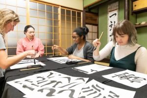 group-doing-japanese-calligraphy-during-team-building-event