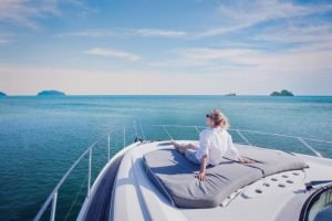 woman sitting on boat looking out into the ocean