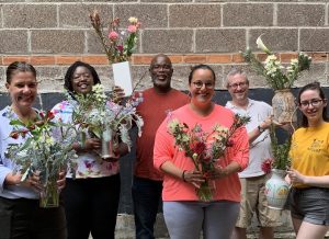 group holding floral designs during nyc team building